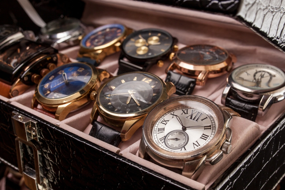A storage black leather box with a collection of men's wrist watches.